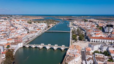 Sahne Tavira 'yı yukarıdan, Gilao Nehri' ni, birkaç Roma köprüsünü ve Portekiz 'deki açık mavi gökyüzünün altındaki kasabaları vurguluyor..