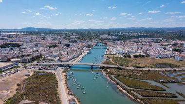 Tavira yukarıdan nehir, tekne ve binaların planlarını gösteriyor. İnsansız hava aracı açık bir günde Algarve kasabasının özünü yakalıyor..