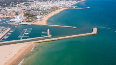 Vilamoura marinası, kıyı şeridi boyunca Portekiz 'in bu popüler turizm bölgesinde açık bir gökyüzü altında uzanan teknelerle meşgul. Havadan