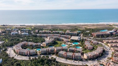 Portekiz, Albufeira 'daki Salgados tatil beldesi. Bölgede binalar, bahçeler, havuzlar ve Algarve bölgesinin kıyı şeridi yer alıyor..