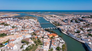 İnsansız hava aracı görüntüsü, Algarve 'de nehirler, Roma köprüleri ve çeşitli yapılarla Tavira' yı yakalar. Arka planda kıyı şeridi ve manzaralar görülebilir..
