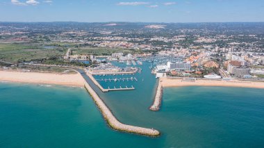 Ziyaretçiler, Portekiz 'in Algarve bölgesinde rıhtıma yanaşmış ve kumlu sahilleri olan Vilamoura marinasının keyfini çıkarıyorlar..