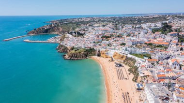 Ziyaretçiler, berrak suları ve kumlu kıyılarıyla Portekiz 'in Albufeira plajının keyfini çıkarıyorlar. Bu popüler nokta Algarve bölgesinde önemli bir noktadır..