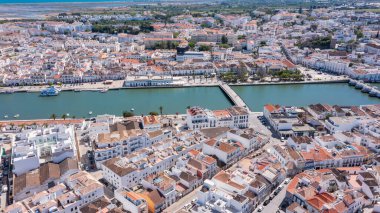 Bu hava manzarası, Gilao nehri boyunca uzanan binalarla Algarve 'da Tavira' yı yakalar. Tekneler denizde görülebilir, şehir planlarını ve yapılarını sergiliyorlar.