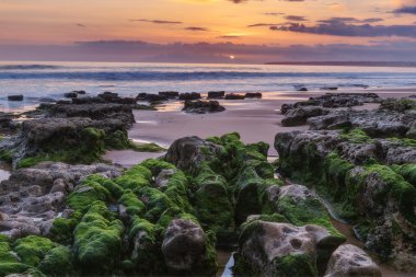 Gün batımından önce deniz büyülü manzara. Yeşil algler buzlu. Albufeira beach Gale.