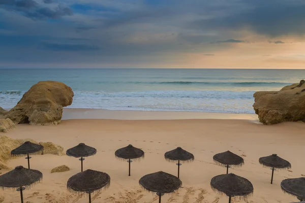 Dramatische uitzicht op het strand met parasols voor de zon. Voordat de regen. — Stockfoto