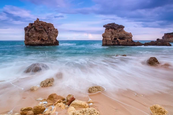 Floue vagues écoulement vers le bas le long de la côte rocheuse. Beau paysage avant la tempête. — Photo