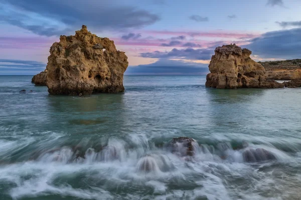 Acantilados en el mar en el atardecer. Ondas borrosas. — Foto de Stock