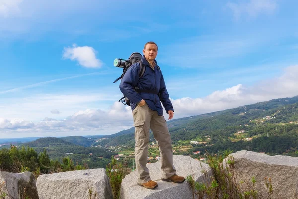 Uomo di mezza età con uno zaino sullo sfondo del paesaggio della montagna. — Foto Stock