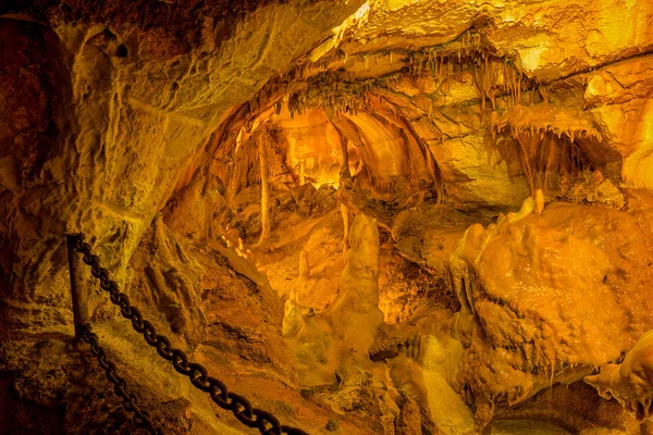 Heavy metal chain in caves da Moeda with stalactites and stalagmites. — Stock Photo, Image