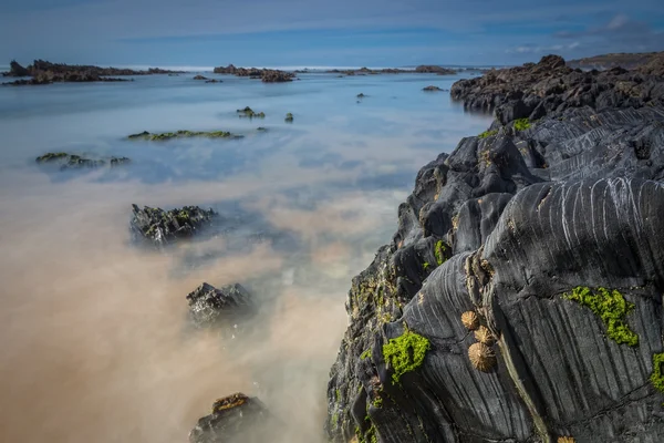 Mágico paisaje marino en larga exposición. Roca volcánica en primer plano. — Foto de Stock