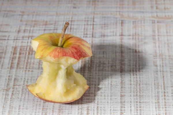 Trognon de pomme sur une table en bois. Avec Shadow. — Photo