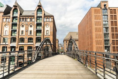 Hamburg liman bölgesinde tahta köprü ve tarihi tuğla mimari.