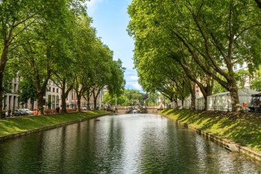 Tarihi Konigsallee kanalı Almanya 'nın Düsseldorf kentindeki eski ağaçlar ve su yansımalarıyla çevrilidir.