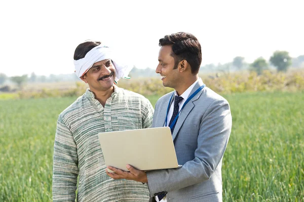 Agricultor com empresário usando laptop no campo da agricultura — Fotografia de Stock