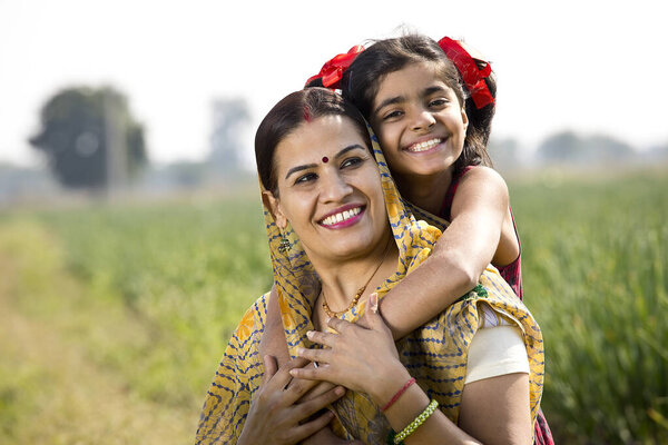 Счастливые мать и дочь на сельскохозяйственном поле