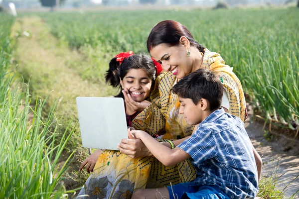 Mãe com crianças usando laptop no campo da agricultura — Fotografia de Stock