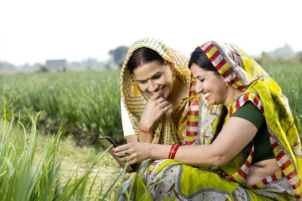 Zwei glückliche Landfrauen telefonieren auf dem Feld — Stockfoto