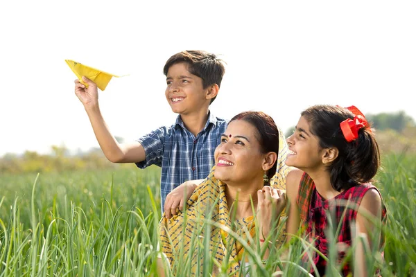 Família rural com menino jogando avião de papel no campo agrícola — Fotografia de Stock