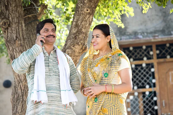 印度农村地区的妻子看着男人用手机交谈 — 图库照片