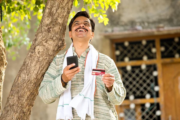Famer χρησιμοποιώντας κινητό τηλέφωνο και πιστωτική κάρτα για την πληρωμή — Φωτογραφία Αρχείου