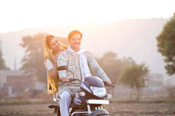 在村子里骑摩托车的快乐农村印度夫妇 — 图库照片