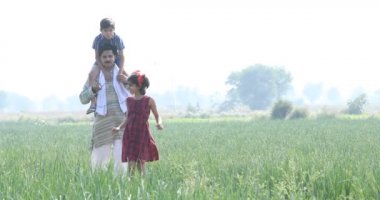 Tarlada oğlu olan mutlu bir çiftçi.