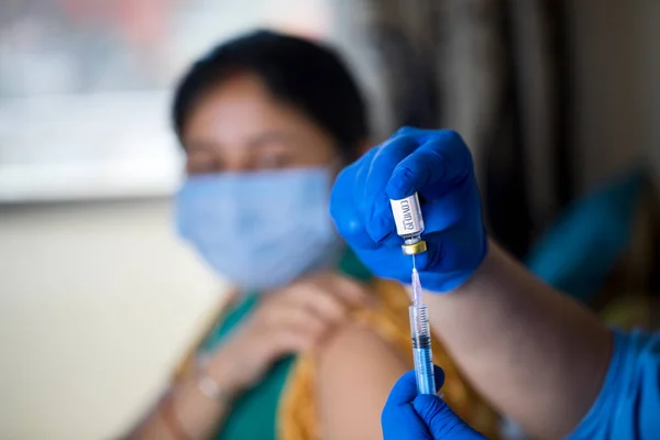 Läkare injicerar vaccin i patientens arm Stockfoto