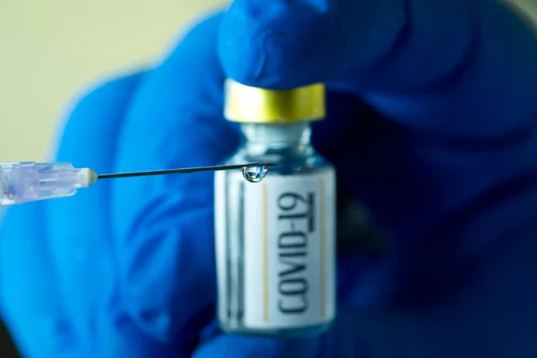 Läkare förbereder injektion med vaccinet covid-19 närbild Stockbild