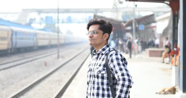 Hombre comprobando el tiempo mientras espera en la estación de tren — Vídeos de Stock