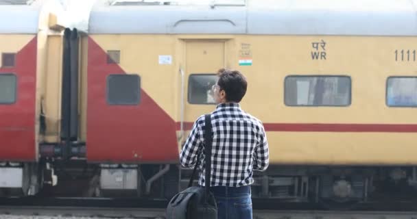 Man checking time while waiting at railway station — Stock Video