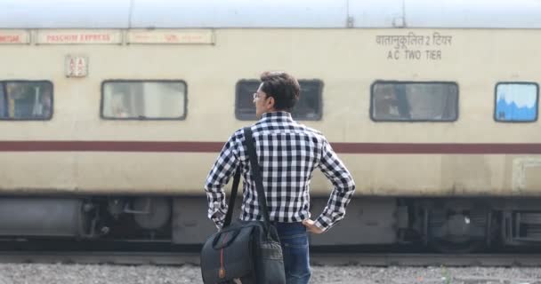 Чоловік перевіряє час очікування на залізничній станції — стокове відео