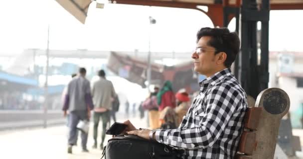 Hombre con bolsa esperando en la plataforma de la estación de tren — Vídeo de stock