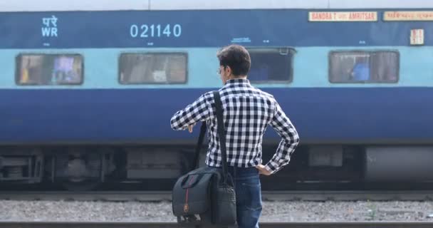 Man die de tijd controleert terwijl hij wacht op het station — Stockvideo