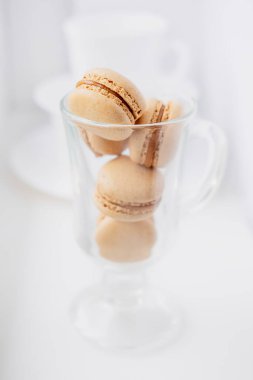 Şeffaf bir bardakta badem kurabiyesi. Karamelli makarna. Tatlı ile hafif bir bembeyaz. Beyaz arkaplanda makarna