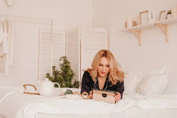 Una Chica Pijama Acuesta Cama Con Una Tableta Comprobación Noticias — Foto de Stock