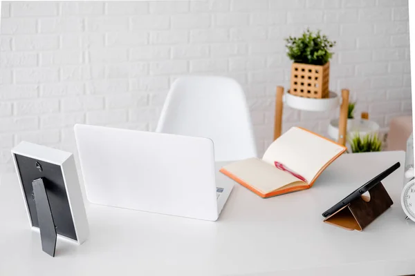 Serbest çalışan işyeri. Laptop, tablet ve günlükle çalışma masası. Açık renkli öğrenci iç mimarisi