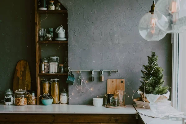 Noel çelenkleriyle süslenmiş bir mutfak. Baharat ve konteynırlarla dolu mutfak köşesi. Hygge tarzı mutfak.