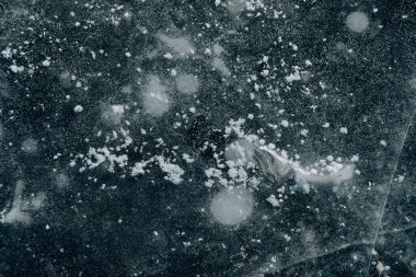 Buzlu göllerin kışın donmuş dokusunun yukarıdan aşağıya doğru görüntüsü. Kış desenli çatırtılı buz. Donmuş gölde buz kabarcıkları..