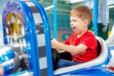 Küçük çocuk binicilikte oynuyor. Çocuk oyun odası. Çocuk bir uçakta oturuyordu. Çocuklarla aktif hafta sonu