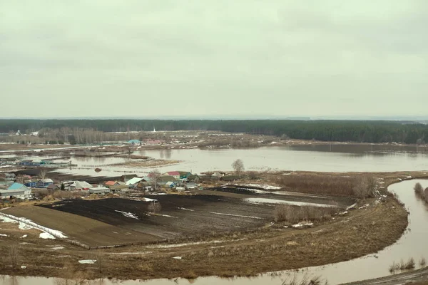 Sel suları evi ve çimenlikteki tarlayı kaplıyor. Yukarıdan bak. Yağmurdan sonra sel