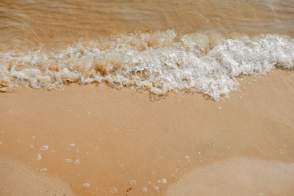 Areia na praia com cor de champanhe. Feche a vista superior. Limpo litoral. Um cenário natural de água e areia — Fotografia de Stock