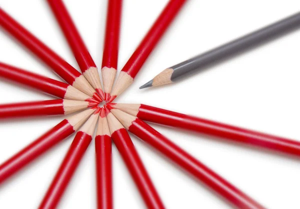 Close up of a black pencil standing out from a circle formed by — Stock Photo, Image