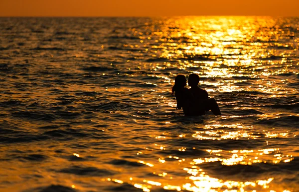 Pareja amorosa al atardecer en el mar — Foto de Stock