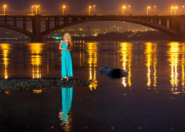 Mädchen in der Nacht am Ufer der Brücke Spiegelung — Stockfoto