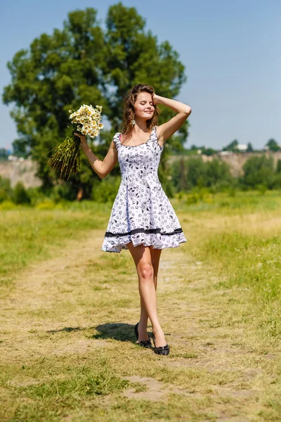 Joven sexy chica con flores en el campo —  Fotos de Stock