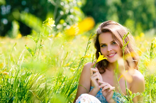 Junges sexy Mädchen mit Blumen auf dem Feld — Stockfoto