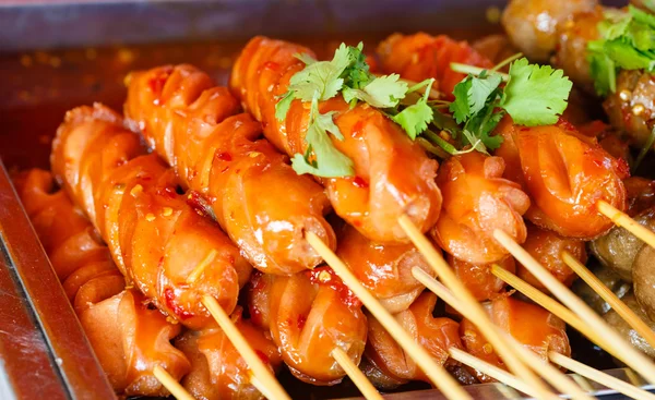 Fried sausage a grill on a stick in sauce — Stock Photo, Image