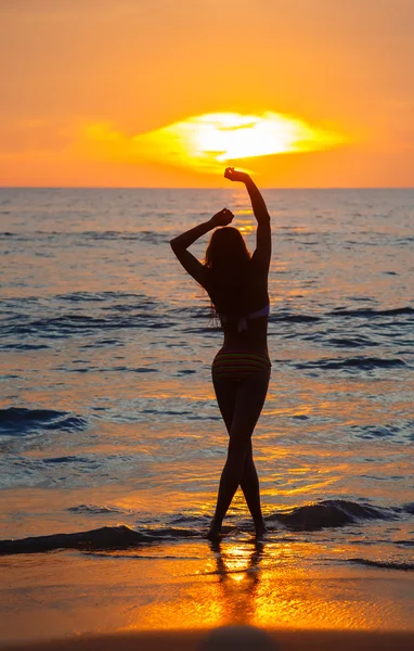 Девушка танцует на закате на берегу моря — стоковое фото