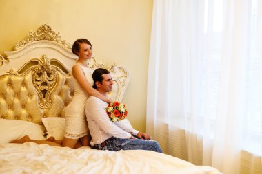 erkek ve kadın bir yatakta çiçekler ile pencereden dışarı bakmak